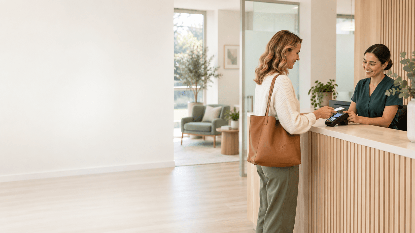 A clinic receptionist helping a patient complete a card payment